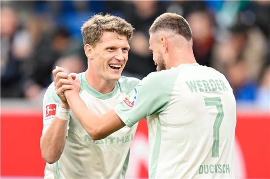 Jens Stage (l) und Marvin Ducksch jubeln über ein Tore von Werder Bremen bei der TSG Hoffenheim. Foto: Uwe Anspach/dpa